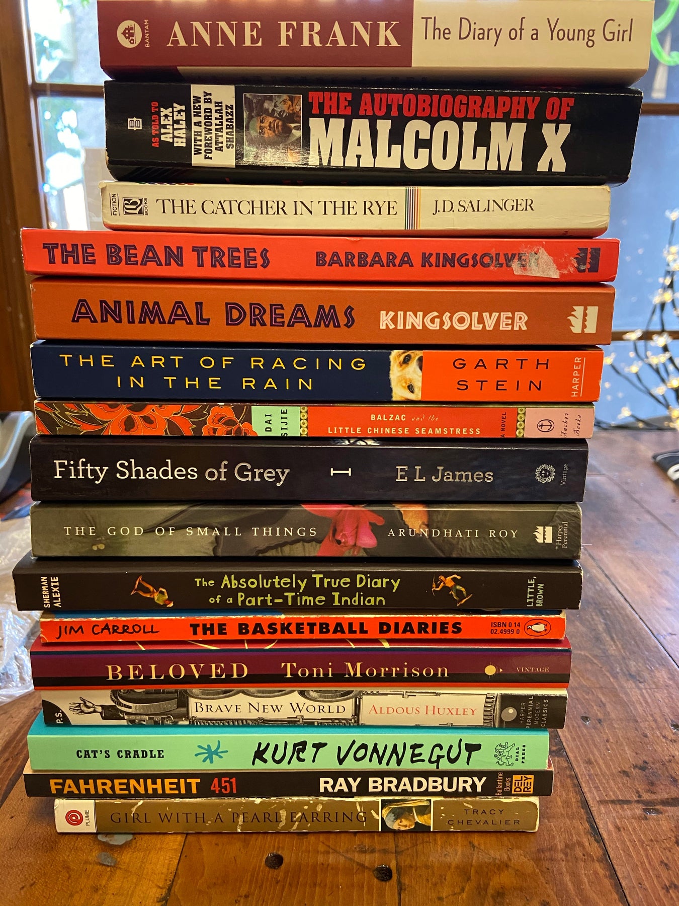 a stack of banned books on a wood table
